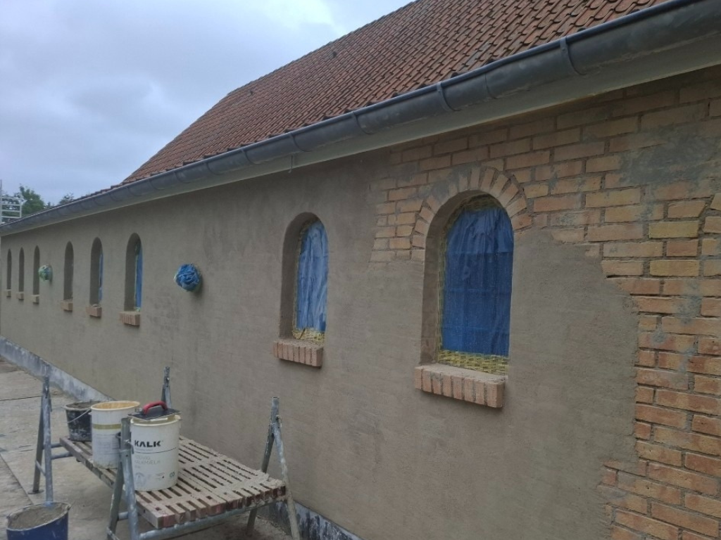 Facade med blåtoneret puds under renovering